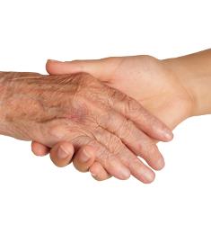 Et yngre menneskes hånd holder et ældre menneskes hånd
